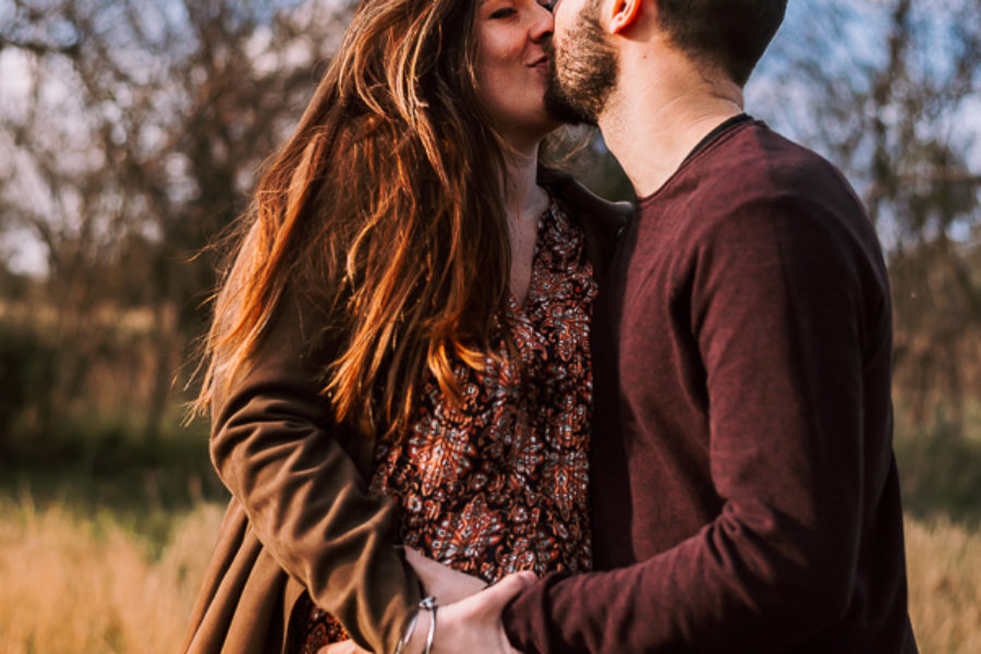 fotografato gravidanza, maternità, coppia che si bacia al tramonto