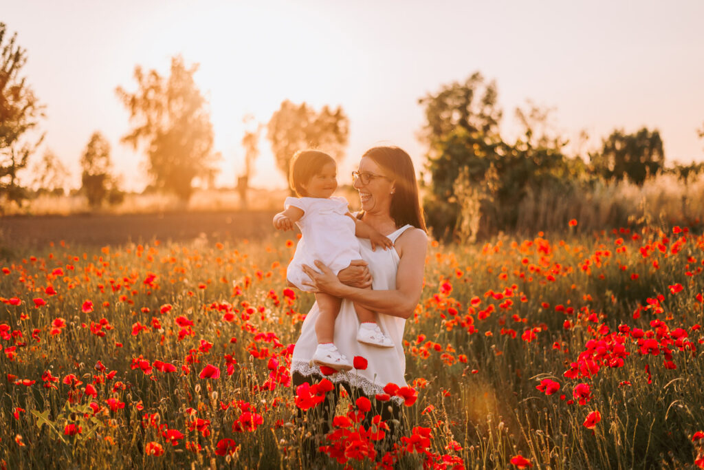 mamma e figlia che si guardano al tramonto tra i papaveri sessione fotografica