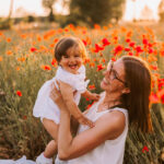 fotografia mamma con bambina tra i papaveri che ridono
