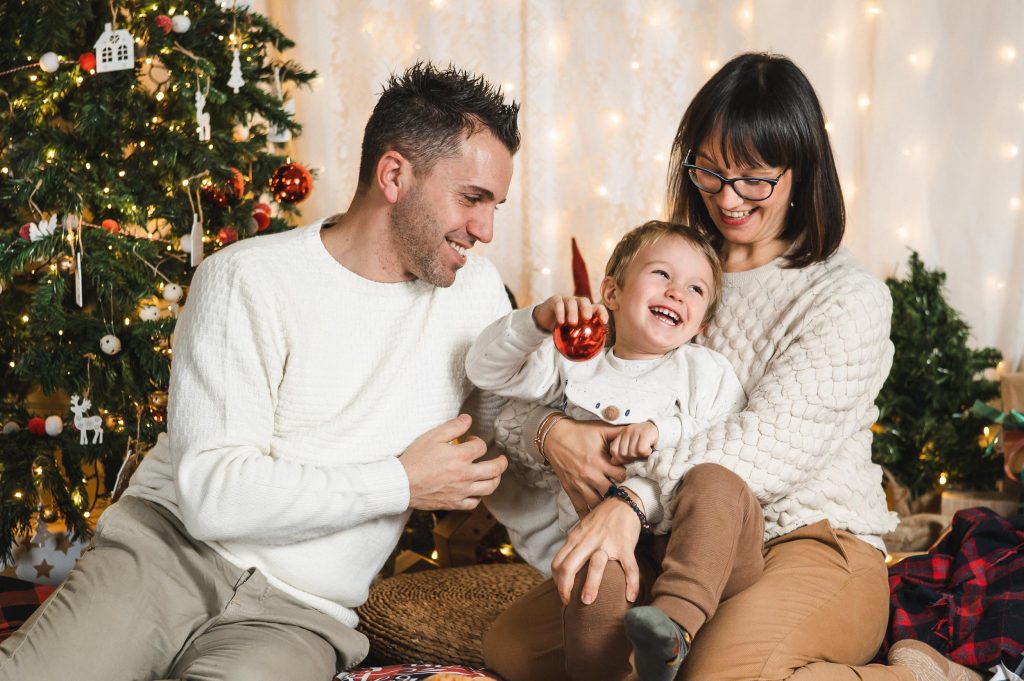Bambino che ride con mamma e papa ritratto Natale