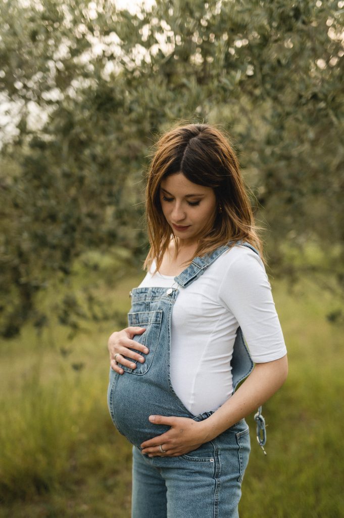 Mamma in attesa con pancione e salopette